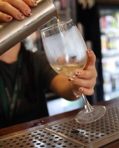 Forum Live Music. Drinks offers, close up of pouring a chilled glass of white wine