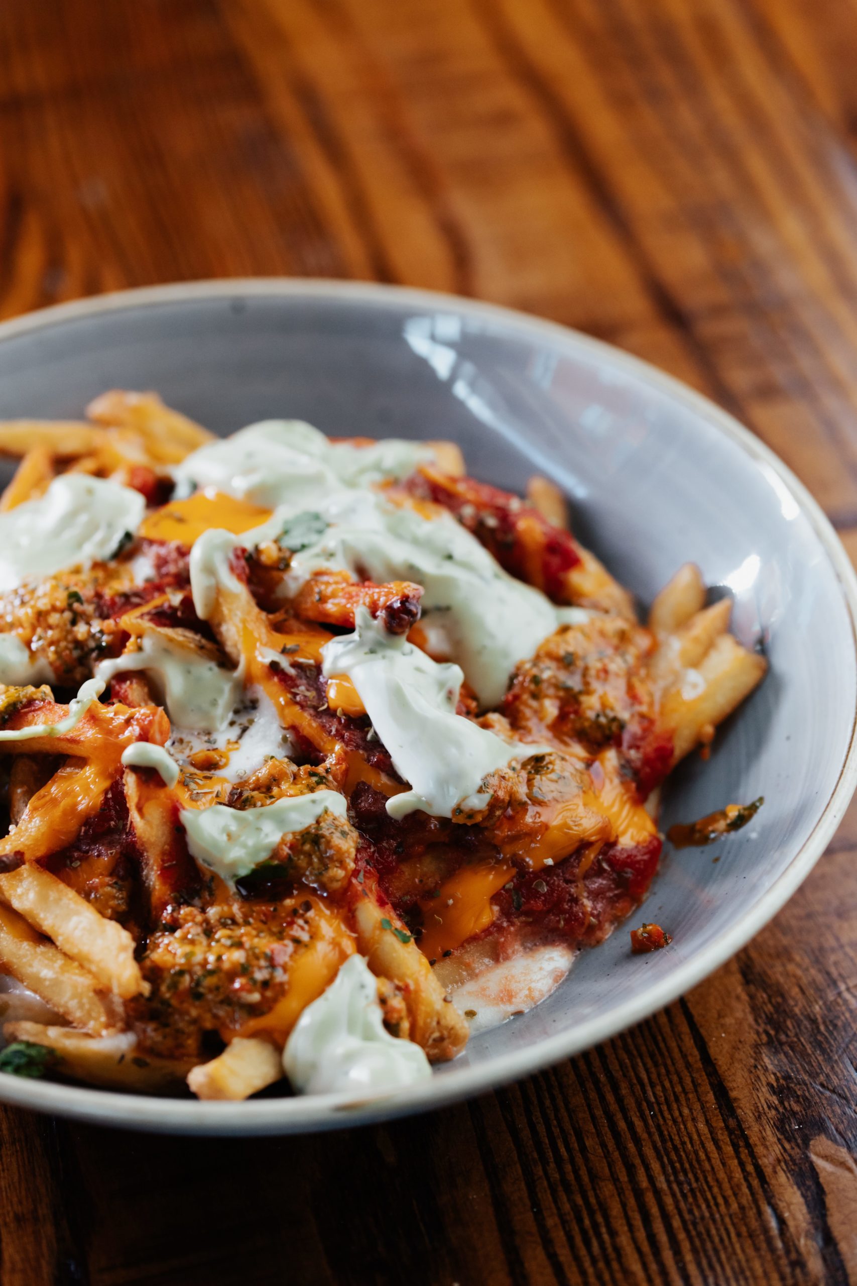 Whole Lot Of Cheese'in loaded fries with mac + cheese bacon bombs, blue cheese dressing, bacon fries, spring onions, coriander